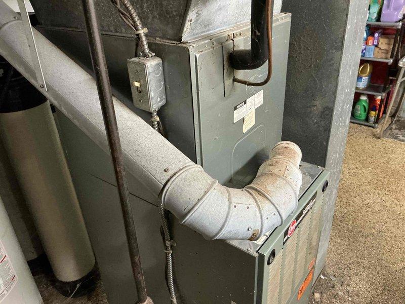 Conducted comprehensive evaluation of existing 20-year-old furnace and central air conditioning system for replacement estimate. Inspected current HVAC equipment installation including air handler unit, condensate drainage system with PVC piping, electrical connections, and associated mechanical components. Documented existing system configuration, photographed equipment condition showing age-related wear, and provided customer with detailed replacement options for complete heating and cooling system upgrade.