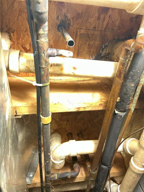 Responded to a water leak in the basement involving a copper water line serving the reverse osmosis system. Upon inspection, identified a hole in the copper line that was causing active water leakage. The damage appeared to have been caused by previous work or interference from another party. Completed necessary repairs to the compromised copper line, restoring proper water supply to the RO system and eliminating the leak. Documented existing plumbing infrastructure and repair work with photographs showing the basement plumbing configuration, including various supply and drain lines, pipe connections, and the affected copper line area.