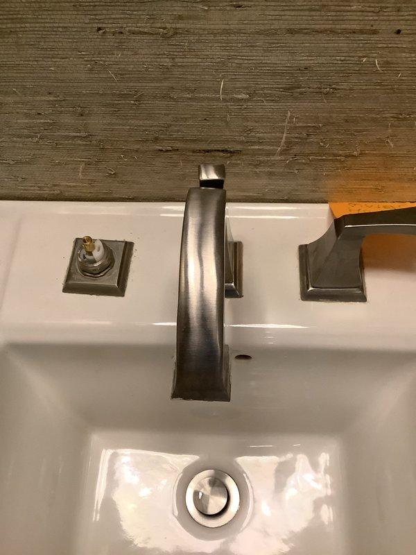 Responded to service call for leaking faucet in downstairs bathroom. Upon arrival, inspected single-handle bathroom faucet with brushed nickel finish mounted on white porcelain sink. Identified leak source and accessed supply line connections beneath sink. Replaced worn flex supply lines with new braided stainless steel hoses, installed new shut-off valves, and tightened all compression fittings to manufacturer specifications. Tested system for proper operation and verified no active leaks present upon completion.