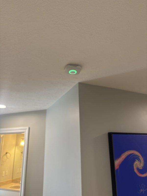 Converted hardwired smoke detectors to battery-powered units in residential property. Installed new battery-operated smoke alarms on ceiling locations in main living area and upper level near staircase, ensuring proper placement and functionality. All units tested and confirmed operational with illuminated status indicators.
