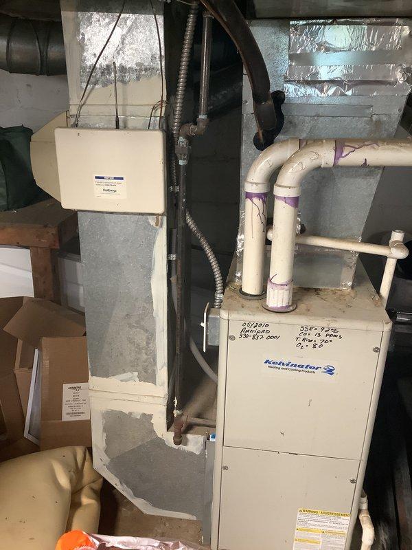Conducted on-site assessment for furnace and air conditioning replacement estimate. Evaluated existing Robinsair furnace system in basement utility area, documented current equipment configuration including ductwork layout, condensate drainage system with PVC piping, and electrical connections. Photographed equipment specifications, mechanical room conditions, and existing HVAC infrastructure to provide comprehensive replacement proposal for both heating and cooling systems.