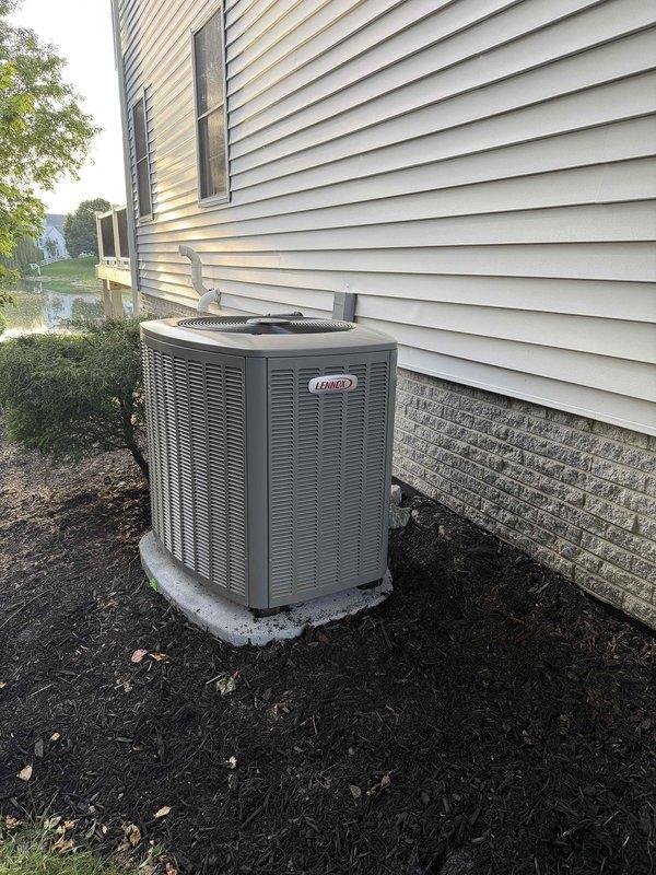 Completed installation of new Lennox air conditioning system with matching evaporator coil at residential property. Outdoor condensing unit was positioned on concrete pad against exterior foundation wall with proper clearance for airflow and serviceability. All refrigerant line sets, electrical connections, and condensate drainage were installed per manufacturer specifications. System was pressure tested, evacuated, and charged to factory requirements, then tested for proper operation and cooling performance.