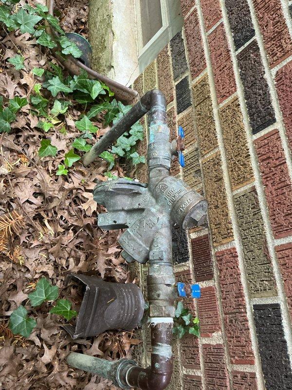 Performed annual backflow prevention device testing on Wilkins brand backflow preventer assembly located at exterior foundation. Inspected dual check valve assembly for proper operation, tested test cocks and shutoff valves, and verified device met municipal compliance standards for potable water protection.