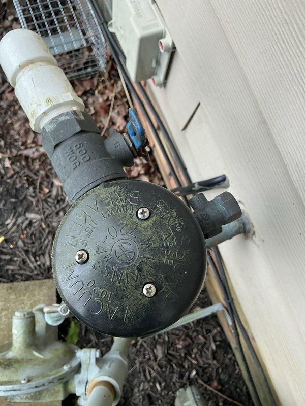 Completed annual backflow prevention device testing on residential property approximately 20-21 years old. Inspected and tested FEBCO backflow preventer assembly showing age-appropriate weathering with green patina on brass components. Device maintains proper functionality with no reported issues or symptoms prior to service. All test ports, check valves, and relief valve inspected and found operational. Pressure differential measurements recorded and verified within acceptable parameters. Device passed testing requirements and remains in service.