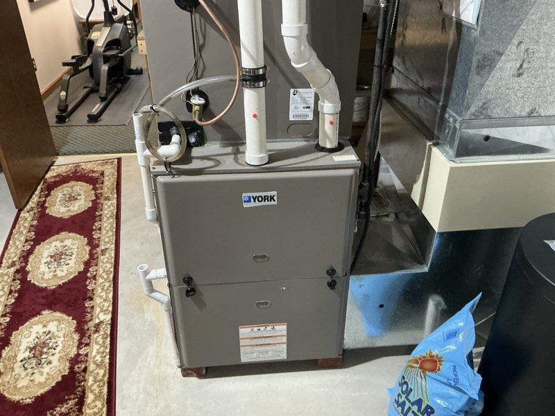 Contacted customer to confirm diagnostic and provided estimate for replacement of 14-year-old air conditioning system and 18-year-old York furnace located in basement utility area. Assessed existing equipment configuration including current venting, ductwork connections, condensate pump, and refrigerant line routing to determine replacement specifications and installation requirements.