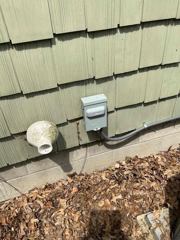 # Electrical Service - Panel/Breakers

Responded to service call for air conditioning unit repeatedly tripping breaker at residential property with 21-year-old electrical panel. Upon arrival, conducted visual inspection of exterior-mounted electrical service panel and associated wiring connections.

## Inspection Findings

Examined main electrical panel box mounted on exterior wall with wood shake siding. Inspected panel cover, conduit connections, and overall panel condition given the age of the installation. Opened panel to assess internal components including breaker arrangement, wire terminations, and bus bar connections.

Observed multiple cable entries at top of panel with various conduit types including rigid metal conduit with compression fittings. Noted complex wire routing with multiple circuits in various colors (black, green, copper, beige, yellow) typical of older residential installations. Identified brass/bronze termination fittings with visible copper conductor strands 