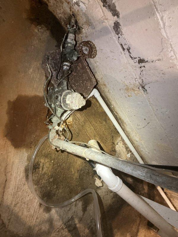 Replaced deteriorated galvanized piping with new copper piping in crawl space and basement utility area. Removed heavily corroded shutoff valves and fittings exhibiting significant oxidation and rust damage at floor-wall junction, installed new copper pipe runs and brass fittings to restore proper water supply functionality and prevent future leaks from corroded connections.