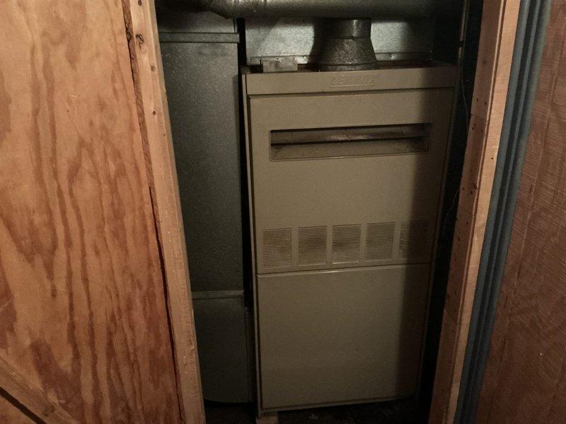 Completed comprehensive estimate for replacement of residential furnace and air conditioning system. Evaluated existing gray furnace unit installed in utility closet with horizontal grille design and top-mounted plenum connection, noting installation configuration between wall studs. Documented current HVAC equipment condition and provided replacement options for complete heating and cooling system upgrade.