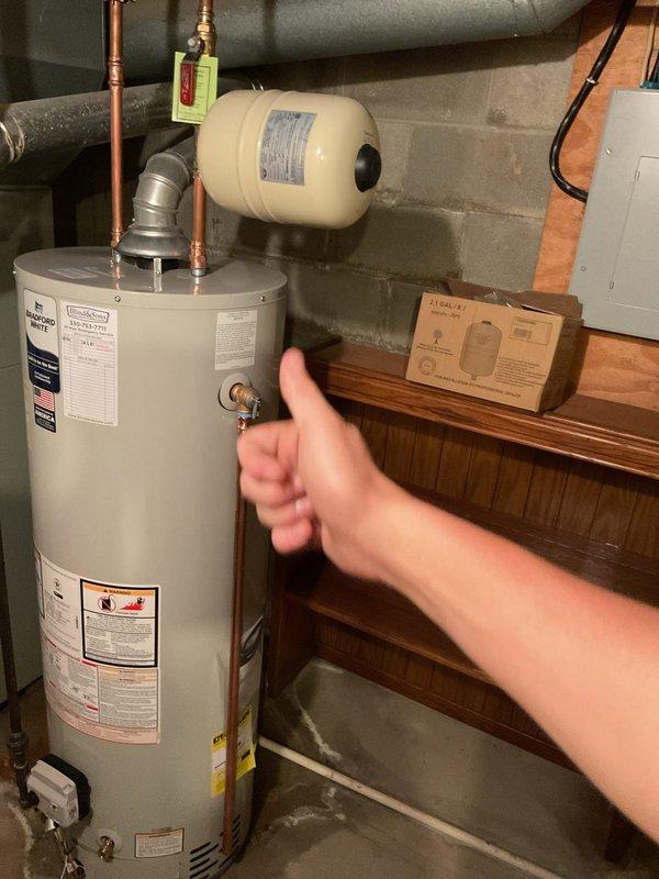 Replaced two existing water heaters with new Bradford White units: a 40-gallon tall model serving the master bath and laundry area, and a 50-gallon unit serving the remainder of the residence. Upgraded cold water shut-off valves on both units and eliminated the hot water shut-off valve on the 50-gallon unit. Installed expansion tanks on both water heaters with proper bonding wire connections. Rebuilt corroded hot and cold water copper lines above the 40-gallon unit from the heater to ceiling-mounted swing joint 90-degree fittings, removing green corrosion-damaged piping. Eliminated the humidifier supply valve during the replumb. Installed drain pan beneath the 40-gallon water heater with discharge line routed to existing sump pump for overflow protection. All installations completed per manufacturer specifications with proper venting and code-compliant connections.