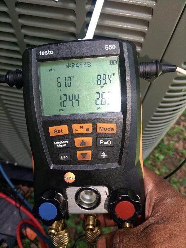 Completed first-time startup and commissioning of new air conditioning system with evaporator coil installation. Verified proper system operation using calibrated digital instruments, confirming supply air temperature of 99.6°F and recording refrigerant pressures for R454B refrigerant at 124.4 psi low side and 75 psi, with ambient conditions at 61°F and return air at 83.4°F, documenting baseline performance parameters for future reference.