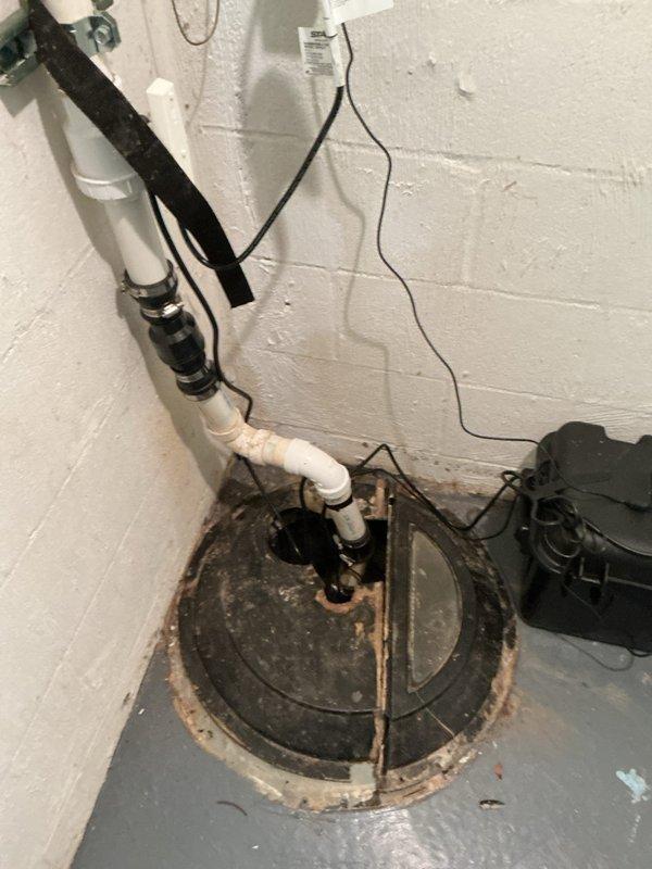 Completed full replacement of wall-mounted Navien tankless water heater unit in residential basement utility area. Removed existing unit and installed new tankless water heater on plywood backing board against cinderblock wall, connecting all copper water supply lines, gas lines, electrical wiring, and white PVC exhaust venting. Installation included proper mounting, connection of all utilities, and verification of operational status with digital display panel functioning correctly.
