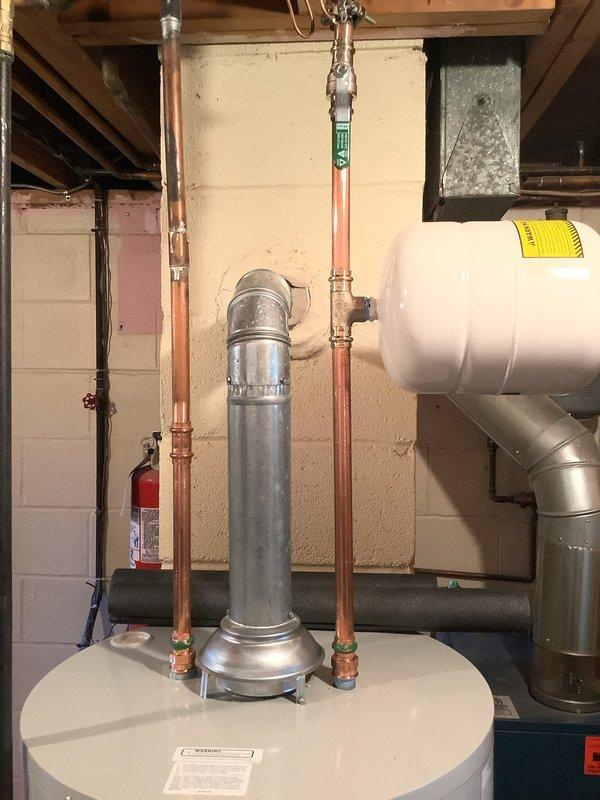 Replaced existing 40-gallon water heater with new Bradford White 40-gallon short model in basement utility area. Installed new water shut-off valve and gas shut-off valve on supply lines. Connected copper water lines with brass fittings and installed expansion tank to system. Verified all connections for proper operation and leak-free performance. Unit includes 6-year tank warranty and was installed with metallic flue pipe venting system.
