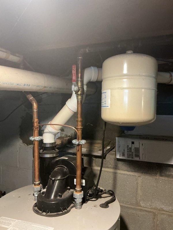 Provided free estimate for water heater and water softener replacement at residential property. Inspected existing 50-gallon Bradford White automatic storage natural gas water heater and associated plumbing system installed in basement utility area. Evaluated hydronic system configuration including white expansion tank, circulation pump with motor assembly, copper supply lines with brass fittings, PVC drainage piping, and pressure regulation components. Documented leaking water softener unit requiring replacement. Assessed current installation setup mounted against concrete block wall, noting copper and PVC pipe routing, electrical connections to pump assembly, and red-labeled valve positioning. Photographed equipment specifications including BTU rating, capacity, and clearance requirements for replacement planning purposes. Reviewed system functionality and provided comprehensive estimate for complete water heater and water softener replacement to address existing leak condition and u