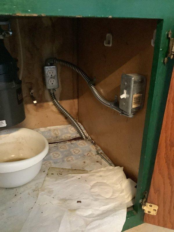 Installed customer-supplied kitchen sink with multiple water supply connections and customer-supplied garbage disposal unit. Reworked existing drain system to accommodate new fixture configuration. Performed electrical work to convert hardwired disposal connection to standard outlet configuration for both disposal and sink accessories. All plumbing connections tested and verified leak-free, disposal operational, and electrical outlet properly grounded and functioning.