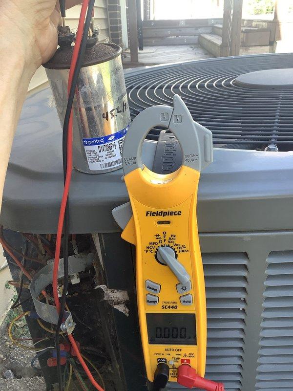 Responded to no-cooling complaint on 8-12 year old residential air conditioning system. Upon arrival, performed diagnostic testing using digital multimeter on outdoor condensing unit. Testing revealed failed dual-run capacitor, which was preventing compressor and condenser fan motor from operating. Capacitor showed visible signs of age, corrosion, and deterioration at terminal connections with accumulated debris around mounting area. Documented failed component with photographs per warranty company requirements for Choice Home Warranty claim processing. Replaced defective capacitor with new unit, verified proper electrical connections, and tested system operation to confirm compressor and fan motor startup. System restored to normal cooling operation with all components functioning within specifications.