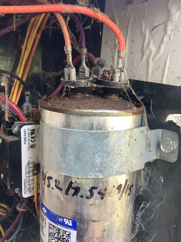 Responded to no-cooling complaint on 8-12 year old residential air conditioning system. Upon arrival, performed diagnostic testing using digital multimeter on outdoor condensing unit. Testing revealed failed dual-run capacitor, which was preventing compressor and condenser fan motor from operating. Capacitor showed visible signs of age, corrosion, and deterioration at terminal connections with accumulated debris around mounting area. Documented failed component with photographs per warranty company requirements for Choice Home Warranty claim processing. Replaced defective capacitor with new unit, verified proper electrical connections, and tested system operation to confirm compressor and fan motor startup. System restored to normal cooling operation with all components functioning within specifications.