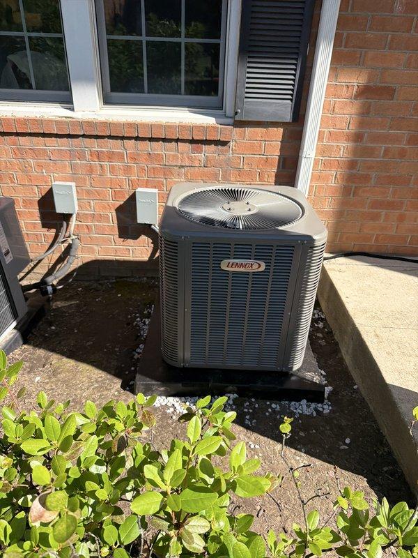 Completed full HVAC system installation including new Lennox outdoor condensing unit positioned on concrete pad with proper mounting and vibration isolation. Established refrigerant line connections with copper piping, service valves, and insulated drainage line, ensuring all connections were properly secured and sealed. System installed per manufacturer specifications with appropriate electrical connections and conduit routing on exterior brick wall.