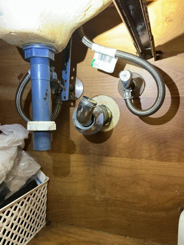 Responded to service call for clogged bathroom sink. Upon arrival, assessed the drainage issue and inspected the P-trap assembly beneath the vanity. Removed and cleaned the blue PVC trap, clearing accumulated debris causing the blockage. Verified proper water flow through the drain system and confirmed all connections were secure with no leaks present. Tested faucet operation and drainage performance to ensure complete restoration of normal function.