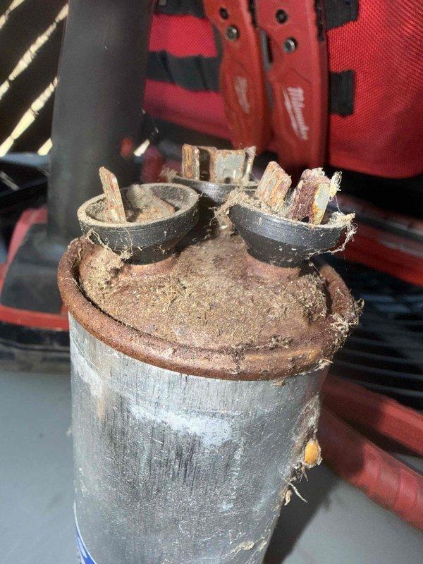 Responded to no cooling call where furnace was running but air conditioning system was not operating. Upon inspection, found failed capacitor with severe corrosion, cracked casing, and deteriorated terminals. Replaced defective capacitor with new unit, verified all electrical connections, and tested system operation. Air conditioning system restored to proper cooling function.
