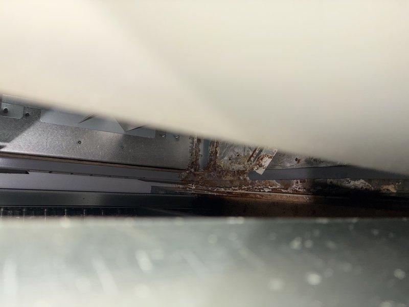 Responded to service call for non-operational air conditioning system. Upon arrival, performed comprehensive system inspection of outdoor condensing unit. Found extensive corrosion on refrigerant lines and mounting components, indicating prolonged exposure to environmental elements. Discovered severely clogged evaporator coil with heavy accumulation of dust, dirt, and debris restricting airflow through the system. 

Documented equipment condition through photographic evidence showing deteriorated metal surfaces, corroded refrigerant lines, and significant buildup within air handler cabinet. The excessive debris accumulation on evaporator coil was identified as primary cause of system failure, preventing proper heat exchange and airflow. Electrical connections and wiring harness inspected and found to be in acceptable working condition despite age of surrounding components.

Recommended thorough evaporator coil cleaning, evaluation of refrigerant line integrity due to corrosion concerns