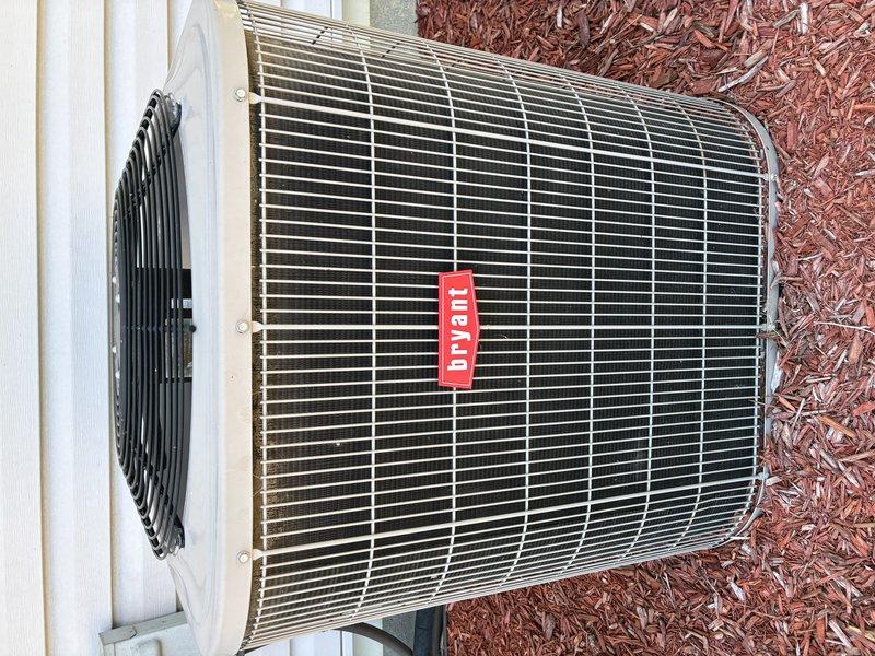 Completed scheduled BS-MVP cooling maintenance visit on Bryant brand outdoor condensing unit. Performed comprehensive system inspection, documenting unit condition and electrical components including capacitor assembly with proper wire connections and secure mounting. Unit found operating properly with clean exterior surfaces, functional fan assembly, and all electrical connections intact on stable concrete pad foundation.