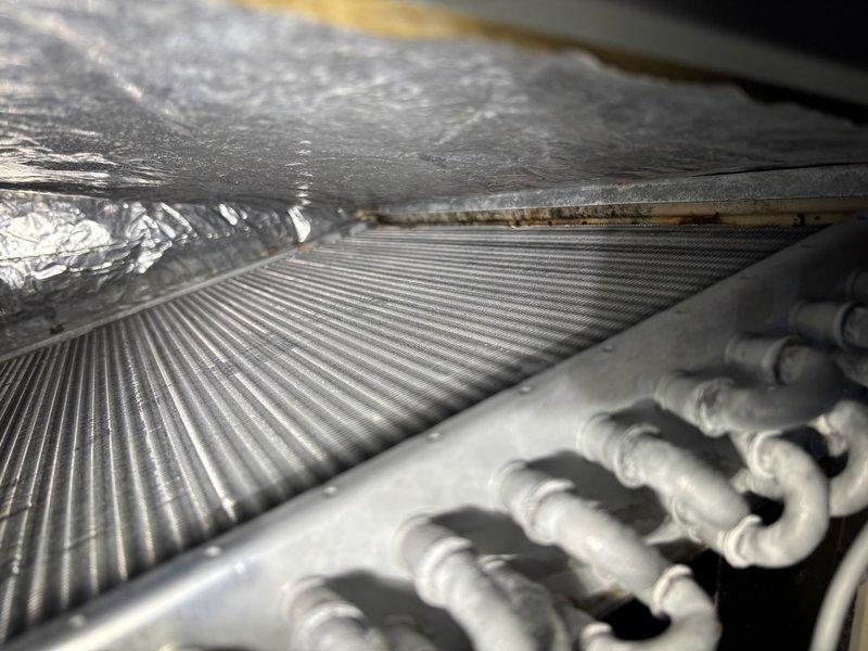 Completed scheduled commercial HVAC maintenance on air handler unit experiencing recurring cooling issues. Performed comprehensive inspection of approximately 5-year-old system, accessing internal components to evaluate evaporator coil condition, electrical connections, and control board functionality. Observed dust accumulation on heat exchange fins and documented moisture staining on exterior insulation, indicating potential condensate drainage concerns. Verified refrigeration line integrity and system operation to address reported cooling performance problems.