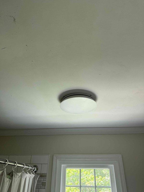 Installed customer-supplied bathroom exhaust fan system, including interior ceiling-mounted light fixture with bronze trim ring and white diffuser, and exterior wall vent with louvered cover on vinyl siding. All components were properly wired, secured, and sealed to ensure proper ventilation and weather protection.