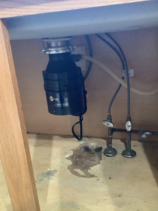 Installed customer-supplied stainless steel kitchen sink and chrome faucet assembly in granite countertop. Reconnected existing garbage disposal unit to new sink drain configuration and installed new drain piping to accommodate updated fixture layout. All connections tested and verified operational with no leaks detected.
