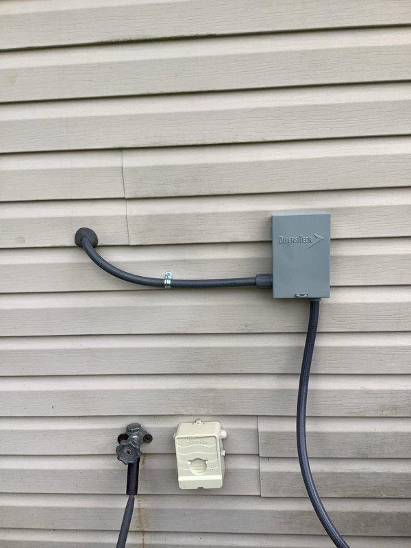 Installed exterior AC disconnect and electrical conduit system on building exterior, mounting Diversitech disconnect box with proper conduit routing through vinyl siding. Completed interior ceiling-mounted security camera or detection device installation with proper wiring and power connection, ensuring all components are operational and meet electrical code requirements.