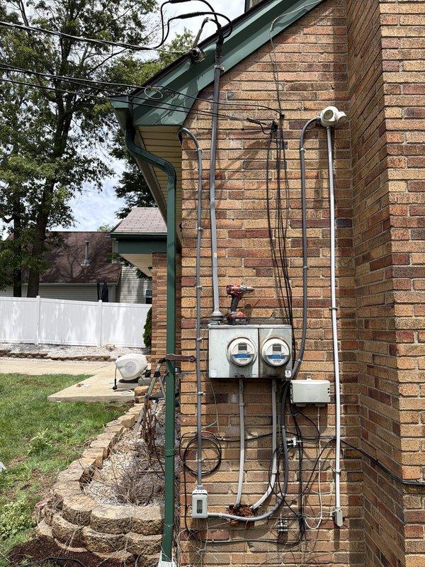 Installed new dedicated electrical circuit for ring light above exterior window. Ran conduit and wiring from existing outdoor outlet, routing above window opening to new fixture location. Completed exterior electrical work with proper weatherproof connections and secure conduit mounting to brick facade.