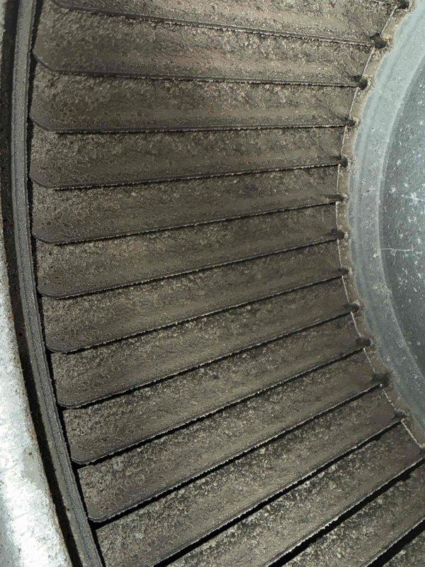 Responded to service call for non-functional air conditioning system in basement area with excessive heat buildup. Upon inspection, found 15+ year old unit with significant maintenance issues including severely clogged evaporator coil with heavy dust and debris accumulation restricting airflow, and visible crack in metal ductwork compromising system integrity. Documented equipment condition with photos showing extent of deterioration and lack of previous maintenance on aging system.
