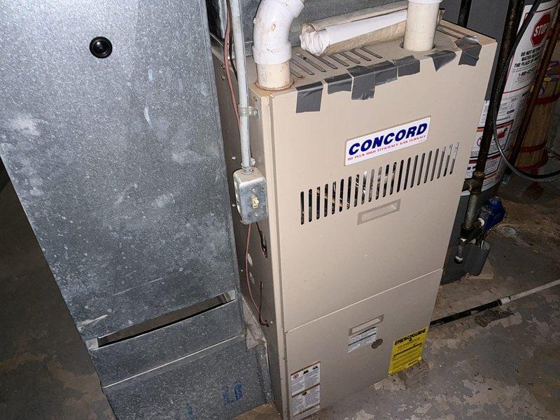 Conducted on-site assessment for complete HVAC system replacement at residential single-family home. Evaluated existing Concord furnace and split-system air conditioning equipment located in basement utility area. Documented current system configuration including ductwork, PVC venting arrangement, and equipment placement. Photographed existing furnace installation showing beige-colored unit with top-mounted PVC exhaust venting, gray metal supply plenum, and concrete floor installation. Assessed basement mechanical space infrastructure including exposed floor joists, concrete block walls, existing ductwork routing, and utility connections. Provided comprehensive replacement quote for new furnace and air conditioning system to homeowner.