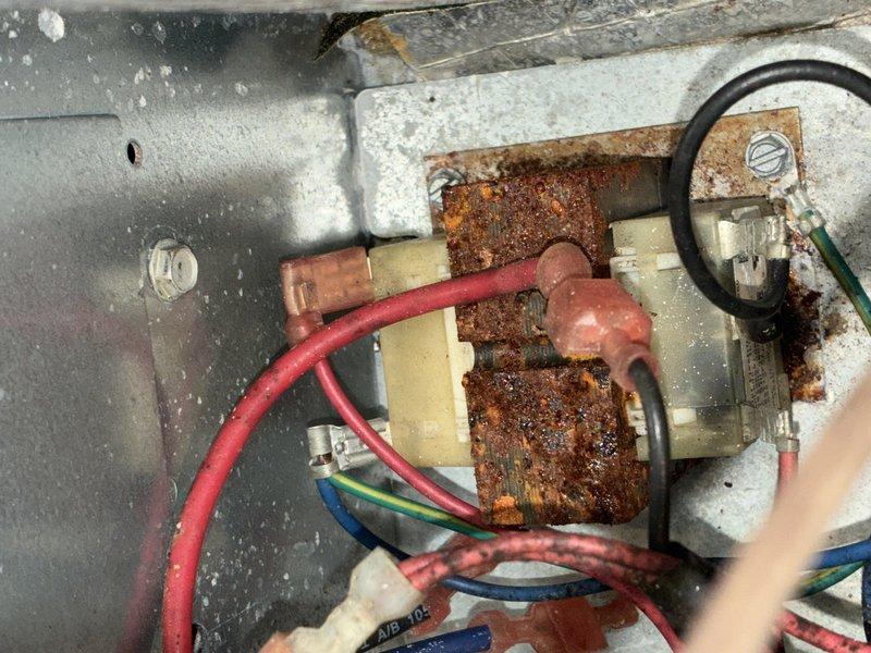 Responded to no-cooling call on 10-year-old air conditioning system. Upon inspection, discovered extensive rust and corrosion on electrical connections and mounting hardware within the unit, along with significant dirt accumulation on heat exchanger coils and wiring compartment. The corroded components and deteriorated connections were preventing proper system operation, causing the unit's failure to start.