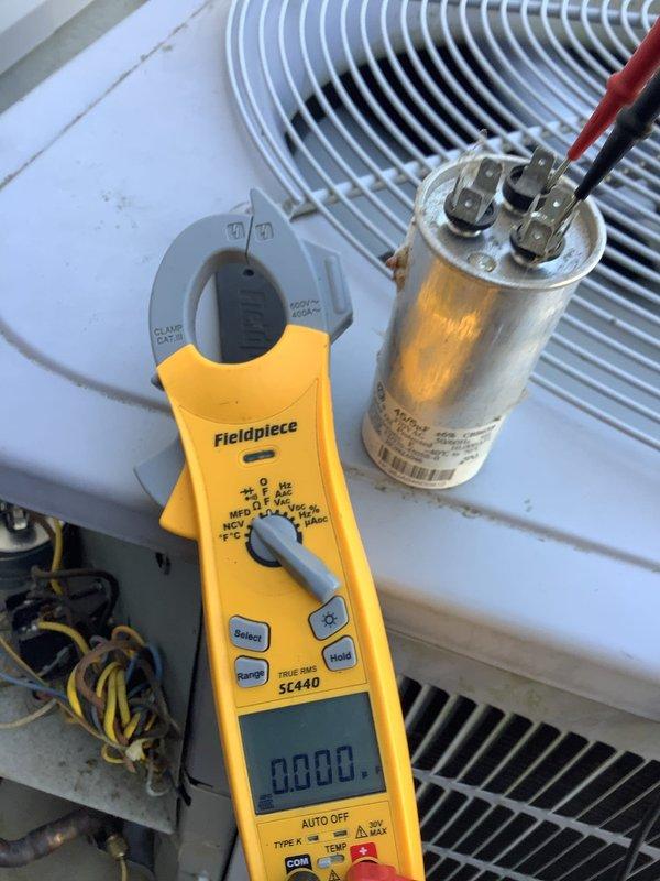 Responded to no cooling complaint on Carrier air conditioning system. Upon arrival, found unit running but not moving air through indoor system. Inspected outdoor condensing unit and tested capacitor using clamp meter. Diagnosed failed capacitor preventing proper compressor and fan motor operation. Replaced defective capacitor with properly rated component, restored system to normal operation, and verified adequate airflow and cooling performance.
