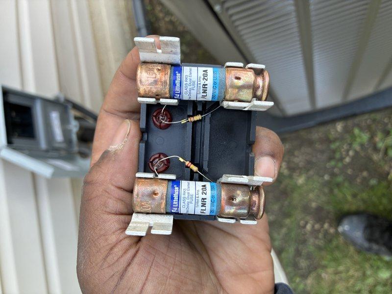 Completed MVP AC maintenance on cooling system. Identified and documented failed 20-amp Littelfuse FLNR fuses in outdoor disconnect switch showing oxidation and weathering from environmental exposure. Inspected electrical disconnect assembly and confirmed fuse failure indicators on safety switch mechanism. Photographed damaged components for service records and customer documentation.