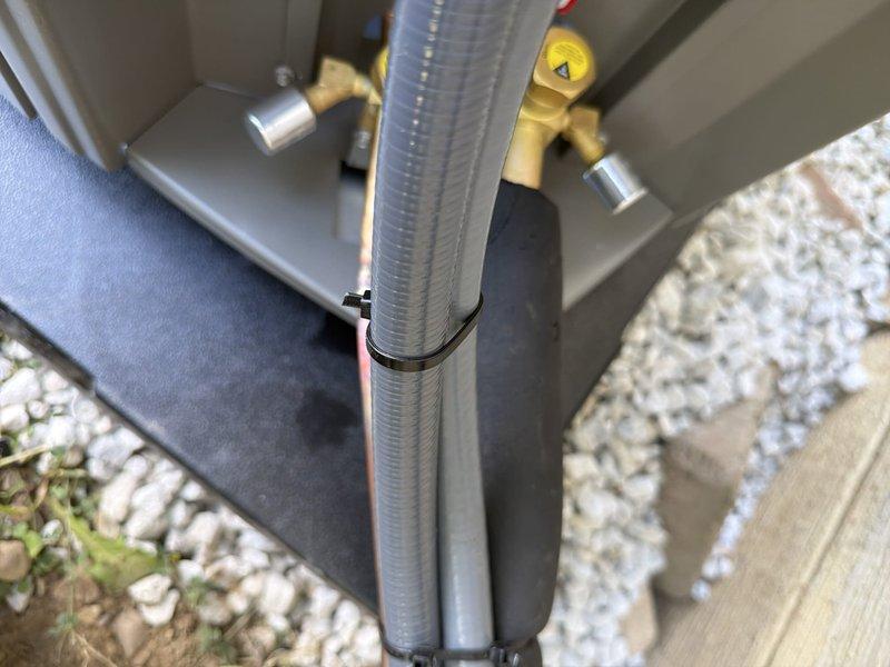 Completed first-time installation of new air conditioning system with evaporator coil. Installed outdoor condensing unit with proper refrigerant line connections, electrical disconnect box with 20-amp Littelfuse fuses, and drainage line secured with appropriate fasteners against exterior wall over landscaped area.