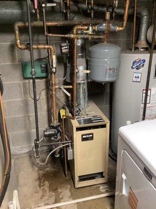 Responded to service call for water leak on 9-year-old residential gas boiler. Upon inspection, discovered moisture accumulation at base of unit and around piping connections. Identified leak source at brass valve fitting in copper piping network near circulator pump assembly. Tightened valve connections and inspected associated piping joints for additional compromised fittings. Verified expansion tank operation and checked system pressure. Monitored unit through heating cycle to confirm leak resolution and proper system operation. All components functioning within normal parameters upon completion.