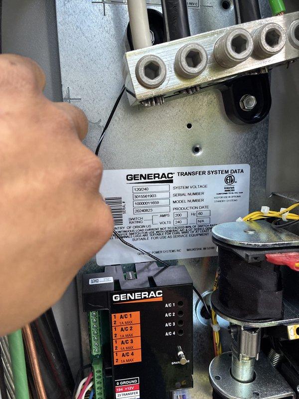 Responded to service call for 18kW Generac generator displaying "engine intake manifold temp alarm" and emergency shutdown after completing test run. Inspected 7-month-old unit and transfer system, reviewed error codes and operational parameters. Photographed transfer system data plate, control module, and electrical panel configuration showing main breakers and circuit connections. Advised customer that reported alarm was not related to possible circuit breaker warranty concern mentioned. Determined issue to be chargeable repair not covered under maintenance agreement.