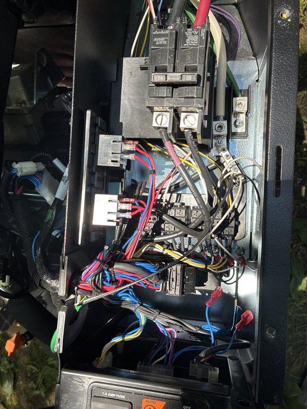 Responded to service call for 18kW Generac generator displaying "engine intake manifold temp alarm" and emergency shutdown after completing test run. Inspected 7-month-old unit and transfer system, reviewed error codes and operational parameters. Photographed transfer system data plate, control module, and electrical panel configuration showing main breakers and circuit connections. Advised customer that reported alarm was not related to possible circuit breaker warranty concern mentioned. Determined issue to be chargeable repair not covered under maintenance agreement.