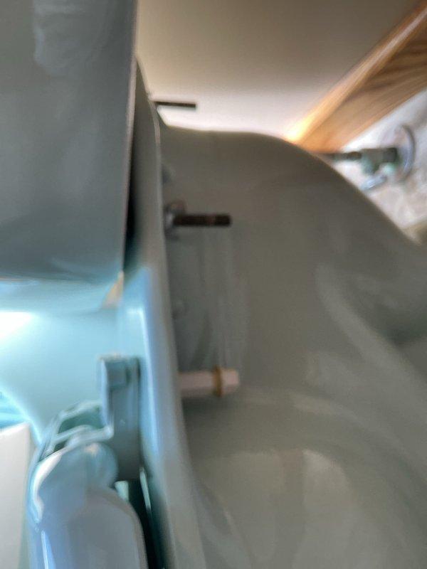 Responded to service call for leaking toilet on first floor and leaky faucet. Upon inspection, discovered toilet tank contained significant mineral buildup, brown staining, and discolored water indicating hard water issues and aging internal components. Assessed flush valve assembly, fill valve with float mechanism, and water supply connections for potential leak sources and deterioration requiring attention.