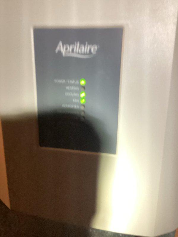 Responded to service call for 7-year-old air conditioning system with clogged condensate drain line. Successfully cleared blockage from condensate line to restore proper drainage and prevent potential water damage or system shutdown. Verified Aprilaire humidifier control panel showing normal operational status with green indicator lights illuminated, confirming system functionality post-service.