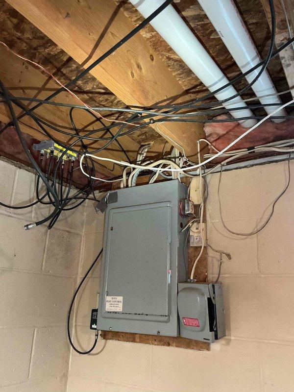 Responded to main breaker tripping issue that began following recent AC installation. Breaker was tripping immediately upon reset, then later would hold for approximately one hour before tripping again. Inspected electrical panel and AC circuit wiring in basement utility area. Identified improper wire sizing on newly installed AC system causing excessive load on main breaker. Corrected wiring connections and verified proper breaker sizing for AC unit load requirements. Tested system operation and confirmed main breaker holding steady with AC unit running under normal load conditions.