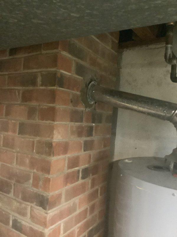 Conducted on-site assessment for furnace and air conditioning system replacement in residential utility area with brick wall construction. Evaluated existing HVAC equipment configuration and documented current installation conditions including clearances, venting arrangements, and electrical service to provide comprehensive replacement estimate for new heating and cooling system.