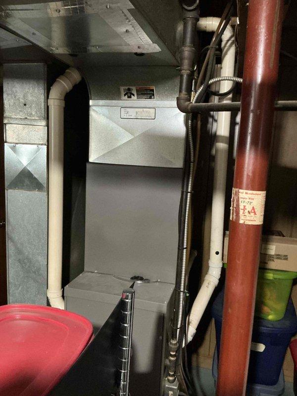 Completed comprehensive HVAC system assessment for equipment replacement estimate in basement mechanical room. Documented existing gray metal furnace/air handler unit, associated ductwork, PVC drainage lines, copper gas line, and electrical connections to provide accurate replacement specifications and installation requirements.