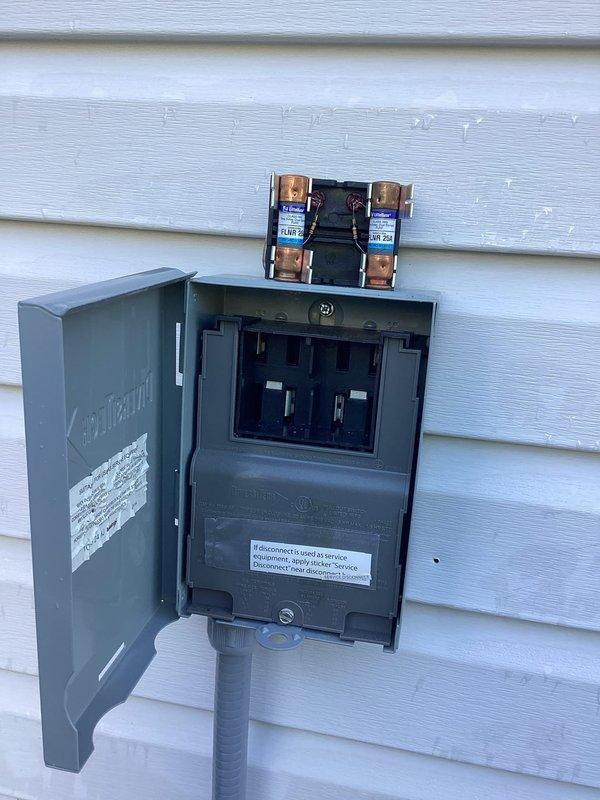 Performed routine air conditioning maintenance and system checkup on residential cooling unit. Conducted electrical testing using digital multimeter to verify proper voltage and amperage at outdoor disconnect box. Inspected dual cartridge fuses and electrical connections at exterior disconnect panel, confirming all components were functioning within normal operating parameters. Unit tested successfully with no issues identified during inspection.