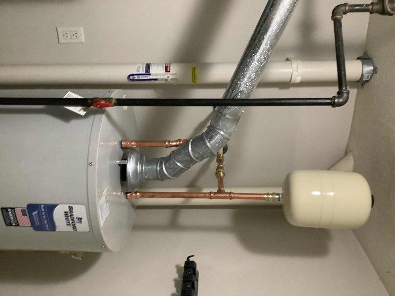 Successfully addressed underground hot water line leak located beneath bathroom adjacent to laundry room. Removed existing bathtub and jackhammered concrete slab to access and repair damaged underground piping. Upgraded plumbing system by replacing 40-gallon water heater with new 50-gallon unit, including installation of expansion tank, new ball valve, and water heater drain pan. Transitioned existing CPVC supply lines to copper piping for improved durability and longevity. Completed rough plumbing connections with exposed framing to accommodate planned bathroom renovation, eliminating need for tub reinstallation at this time.