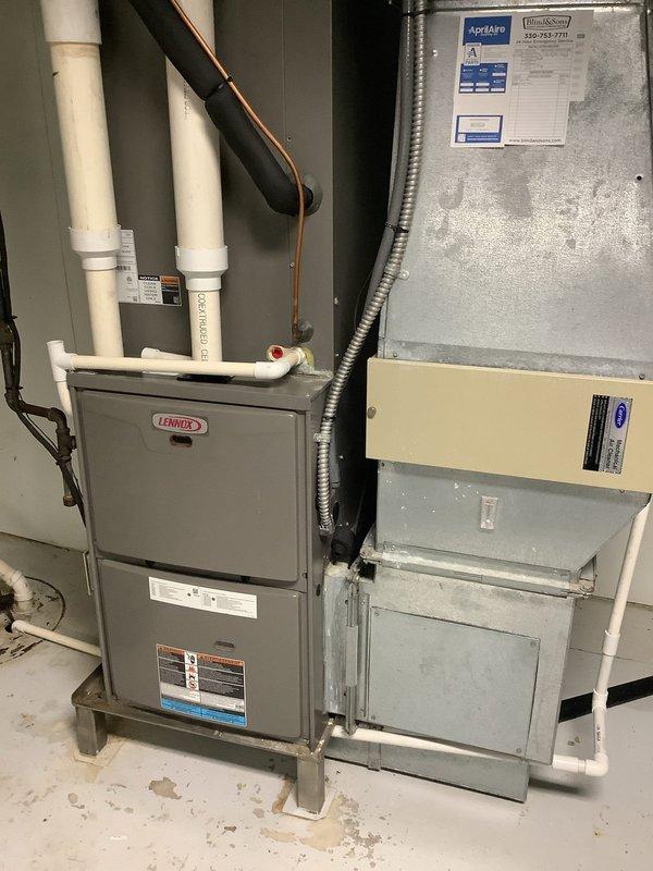 Responded to warranty callback for recurring water leakage from condensation drain line on one-year-old Lennox cooling system. Upon inspection, found significant buildup of algae, mineral deposits, and organic debris inside the PVC condensate drain pipe, evidenced by dark brown and black staining along interior walls. Verified that the indoor air handler and outdoor condensing unit were operating within normal parameters with proper cooling output. Documented condition of drainage system with photographic evidence showing heavy contamination inside drain line that could restrict flow and cause backup. The cooling system is functioning correctly at this time; however, the condensate drain requires cleaning or replacement to prevent future water overflow issues.
