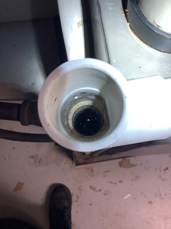 Responded to warranty callback for recurring water leakage from condensation drain line on one-year-old Lennox cooling system. Upon inspection, found significant buildup of algae, mineral deposits, and organic debris inside the PVC condensate drain pipe, evidenced by dark brown and black staining along interior walls. Verified that the indoor air handler and outdoor condensing unit were operating within normal parameters with proper cooling output. Documented condition of drainage system with photographic evidence showing heavy contamination inside drain line that could restrict flow and cause backup. The cooling system is functioning correctly at this time; however, the condensate drain requires cleaning or replacement to prevent future water overflow issues.
