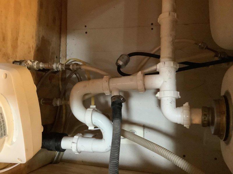 Responded to service call for leaking kitchen sink. Upon inspection, identified water leak originating from under-sink plumbing assembly in basement area beneath fixture. Repaired compromised connections in PVC drain line system and verified integrity of supply line fittings at copper-to-brass connections. Tested all plumbing connections under pressure, confirmed leak resolution, and verified proper drainage from double-basin stainless steel sink with pull-out faucet fixture.