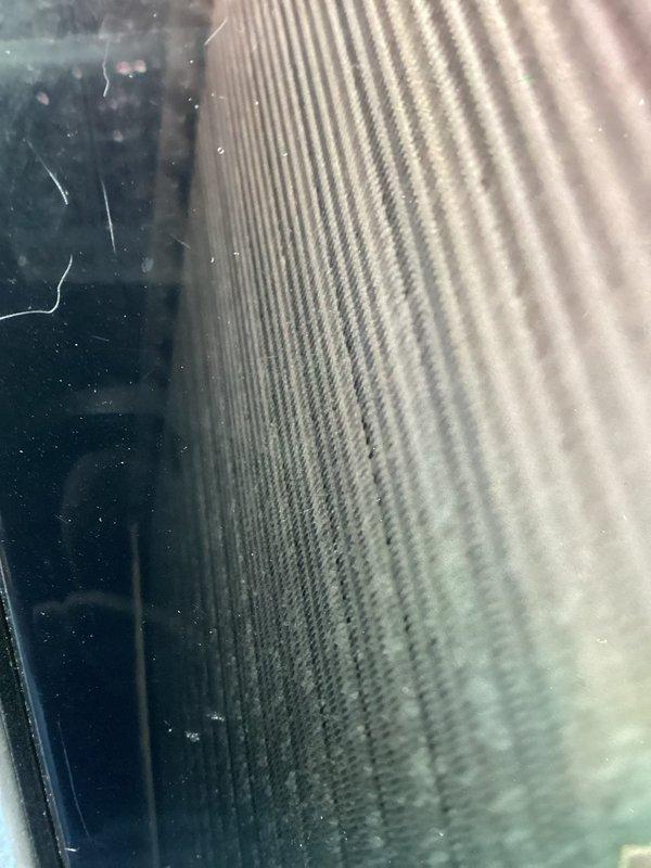 Responded to water leak complaint on 2-year-old air conditioning system. Upon inspection, found evaporator coil heavily contaminated with dirt, dust, and debris buildup restricting airflow and causing condensate drainage issues. Documented existing conditions with photographs showing significant particulate accumulation throughout finned surfaces and reduced system efficiency due to lack of maintenance.